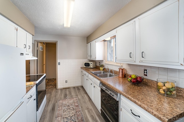 kitchen featuring white appliances, a sink, and white cabinets