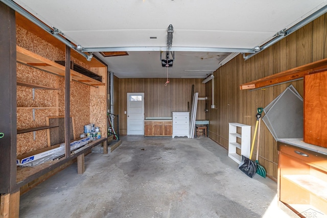 garage with wood walls and a garage door opener