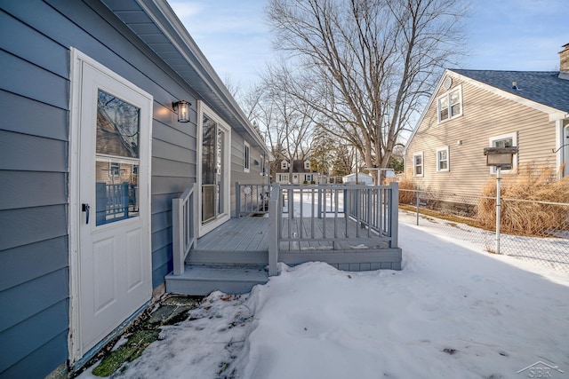 snow covered deck featuring fence