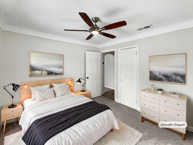 carpeted bedroom featuring visible vents and a ceiling fan