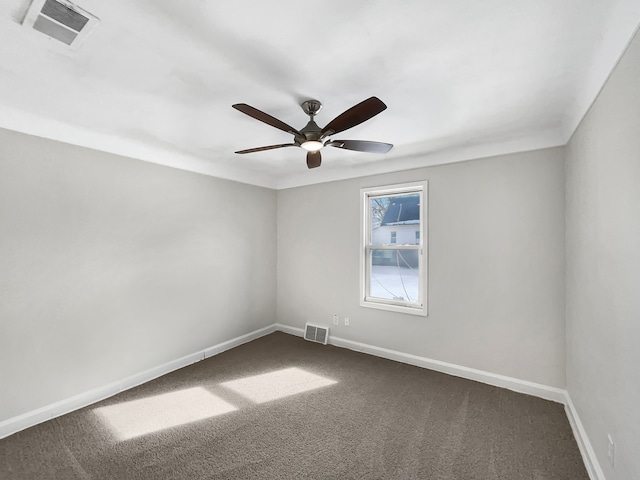 spare room with baseboards, visible vents, and dark colored carpet