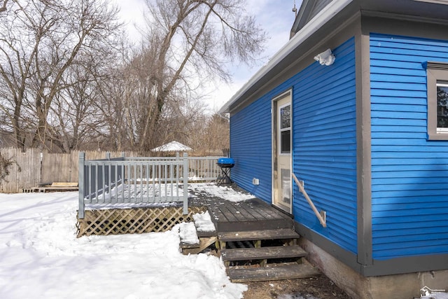 snow covered deck with fence and area for grilling