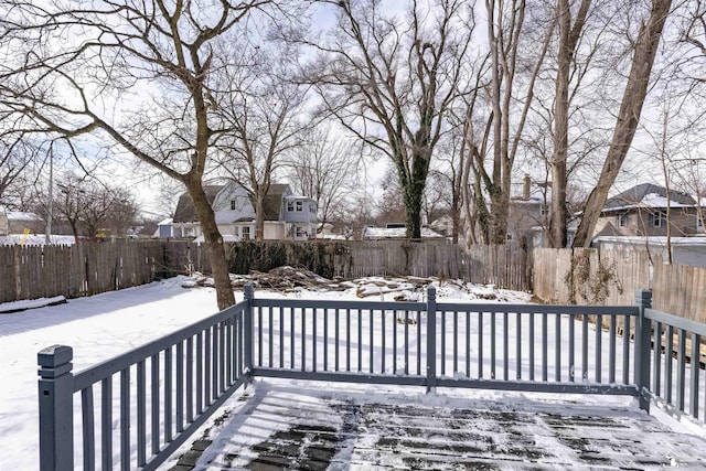 snow covered deck with a fenced backyard and a residential view