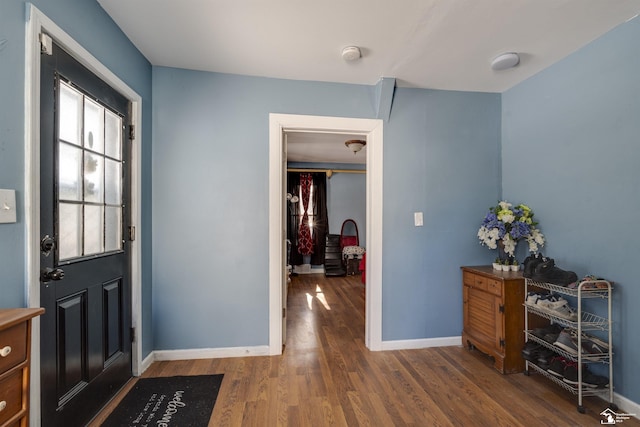 foyer entrance with baseboards and dark wood-type flooring