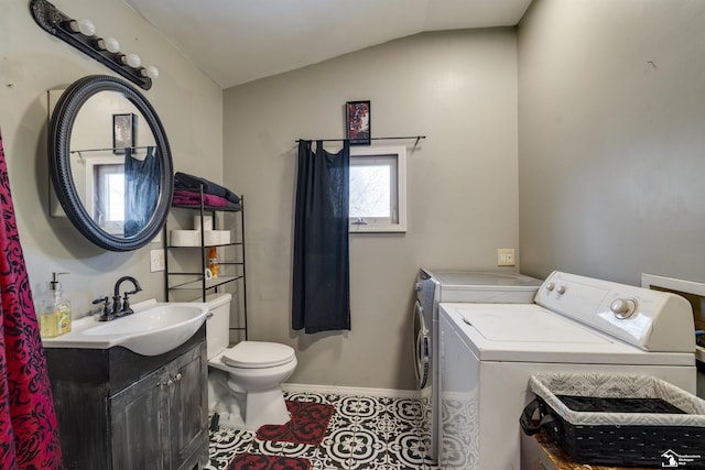 bathroom featuring toilet, vanity, vaulted ceiling, independent washer and dryer, and tile patterned floors