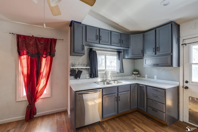 kitchen featuring dark wood-style flooring, a sink, vaulted ceiling, light countertops, and stainless steel dishwasher