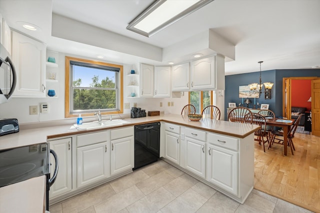 kitchen featuring a peninsula, white cabinets, black dishwasher, light countertops, and pendant lighting