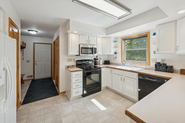 kitchen featuring visible vents, white cabinets, light countertops, black appliances, and a sink