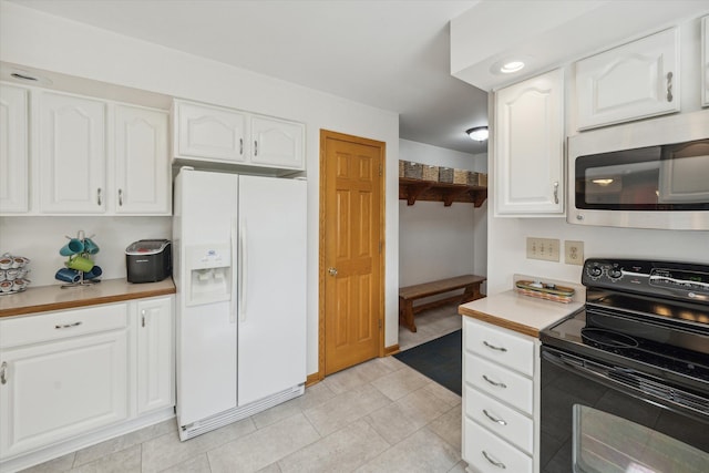 kitchen with white refrigerator with ice dispenser, stainless steel microwave, black electric range oven, light countertops, and white cabinetry