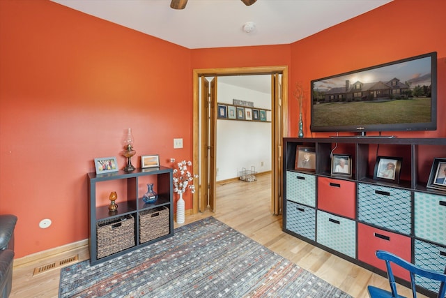 game room with baseboards, wood finished floors, visible vents, and a ceiling fan