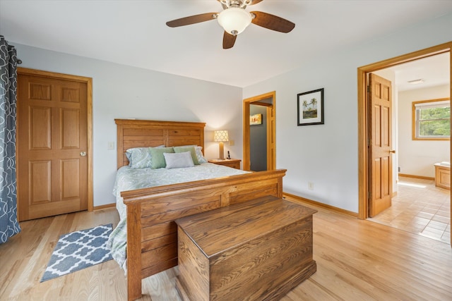 bedroom with ceiling fan, light wood finished floors, and baseboards