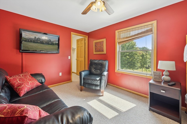 living area with carpet floors, ceiling fan, and baseboards