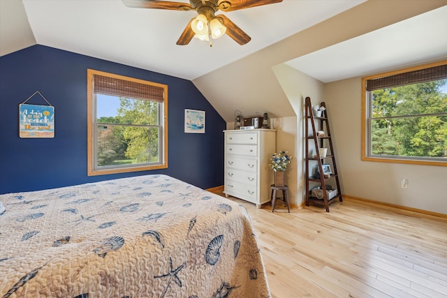 bedroom with lofted ceiling, light wood-style flooring, baseboards, and a ceiling fan