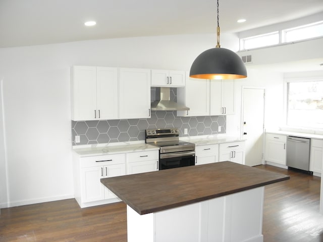 kitchen featuring stainless steel appliances, tasteful backsplash, wooden counters, white cabinetry, and wall chimney exhaust hood