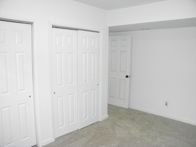 unfurnished bedroom with visible vents, a closet, baseboards, and carpet flooring