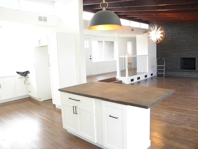 kitchen featuring open floor plan, wooden counters, dark wood-style floors, and visible vents