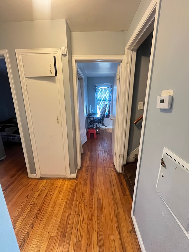 hallway with light wood finished floors and baseboards