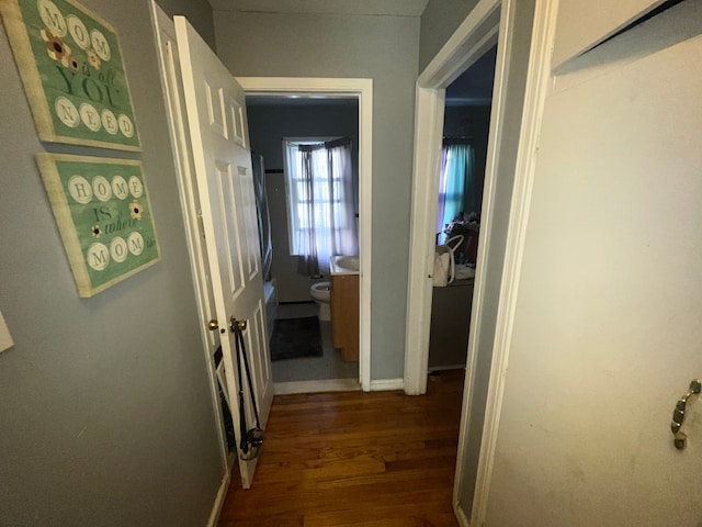 hall featuring dark wood finished floors and baseboards