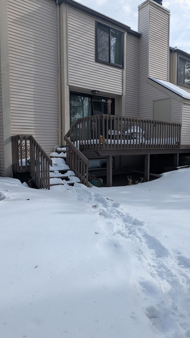 snow covered property with a deck