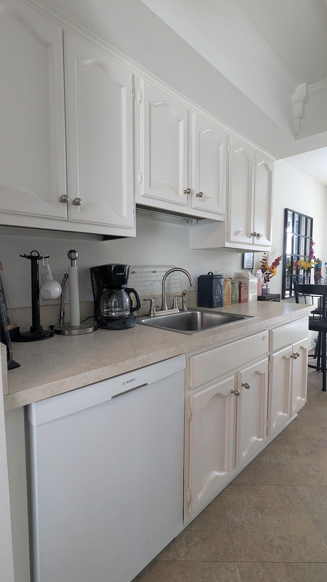 kitchen featuring dishwasher, white cabinetry, light countertops, and a sink