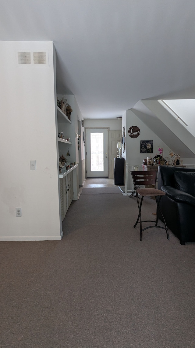 interior space with visible vents, baseboards, carpet, and vaulted ceiling