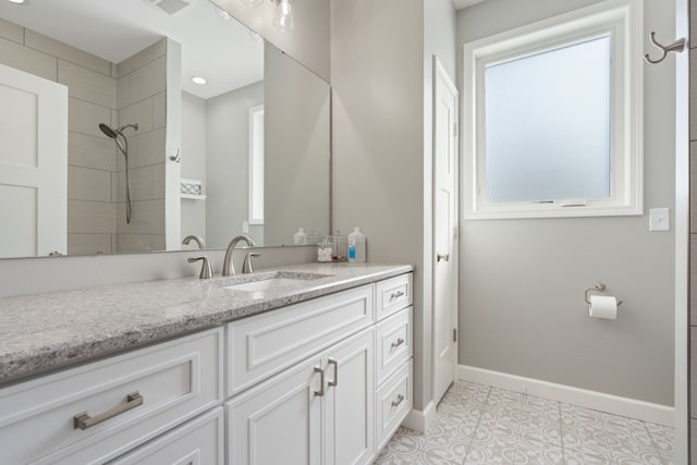 bathroom featuring a shower, baseboards, vanity, and tile patterned flooring