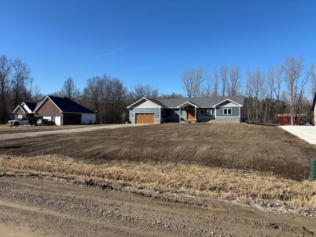view of front of property featuring dirt driveway and an attached garage