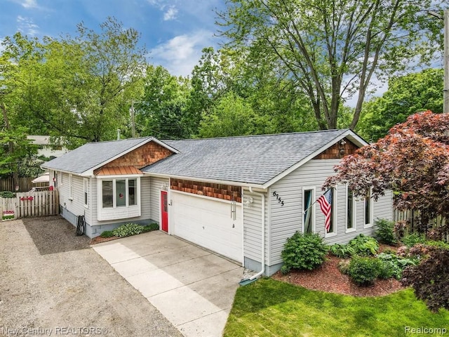 view of front of home featuring a garage, concrete driveway, roof with shingles, and fence