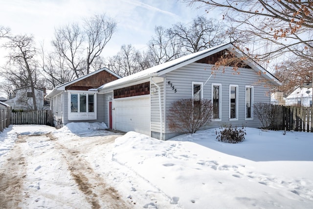 view of front of property featuring a garage and fence