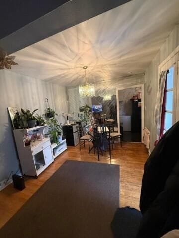 living room with wood finished floors and a notable chandelier