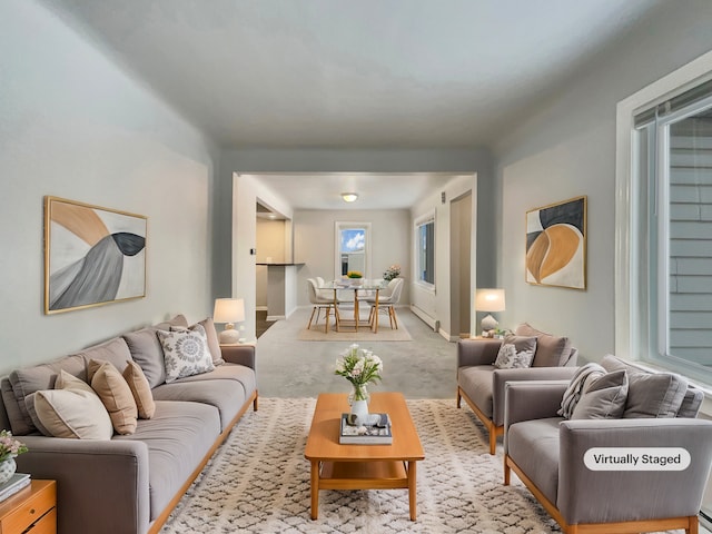 living room featuring baseboards, baseboard heating, and light colored carpet