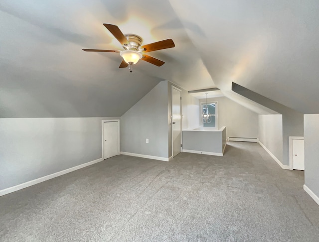 additional living space with a baseboard heating unit, lofted ceiling, carpet flooring, and baseboards