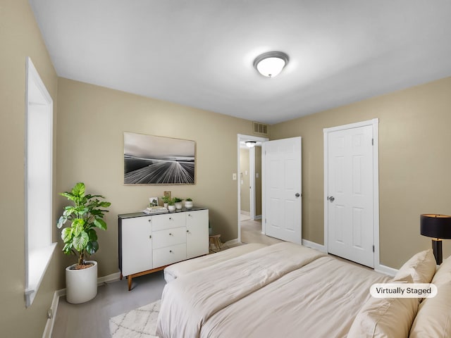 bedroom featuring baseboards and visible vents