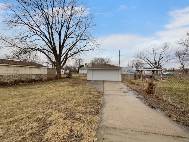 exterior space with a yard, an outbuilding, fence, and a detached garage