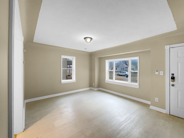 empty room featuring light wood-type flooring and baseboards