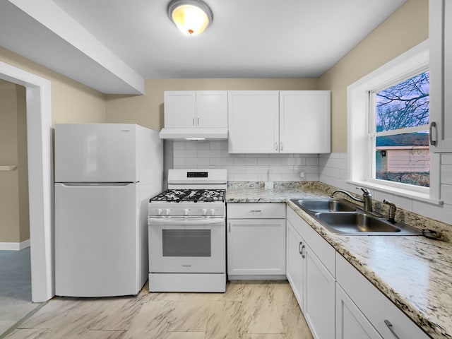 kitchen with under cabinet range hood, white appliances, a sink, and white cabinets