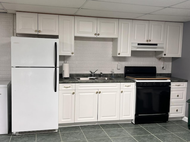 kitchen featuring black range with electric stovetop, freestanding refrigerator, white cabinetry, a sink, and under cabinet range hood