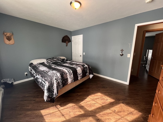 bedroom with baseboards and dark wood-type flooring