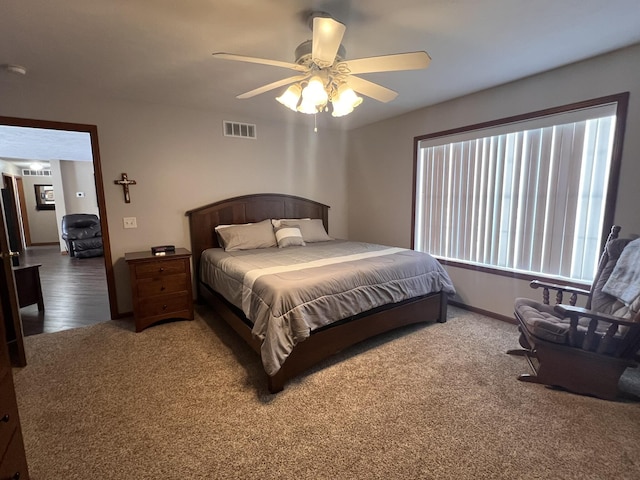 carpeted bedroom featuring baseboards, visible vents, and a ceiling fan