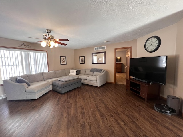 living area with baseboards, visible vents, a ceiling fan, dark wood-style flooring, and a textured ceiling