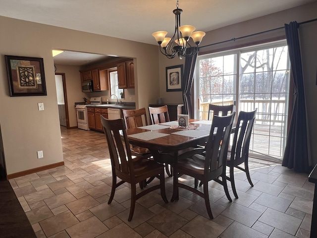 dining room featuring an inviting chandelier and baseboards