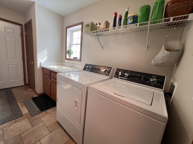 laundry room with cabinet space, a sink, and independent washer and dryer