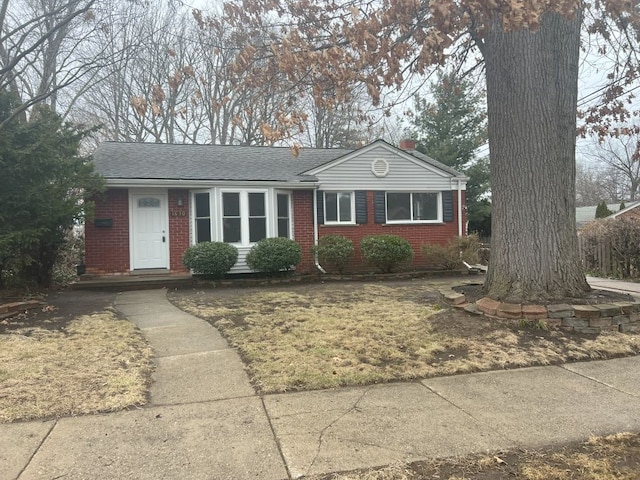 single story home with brick siding and a shingled roof