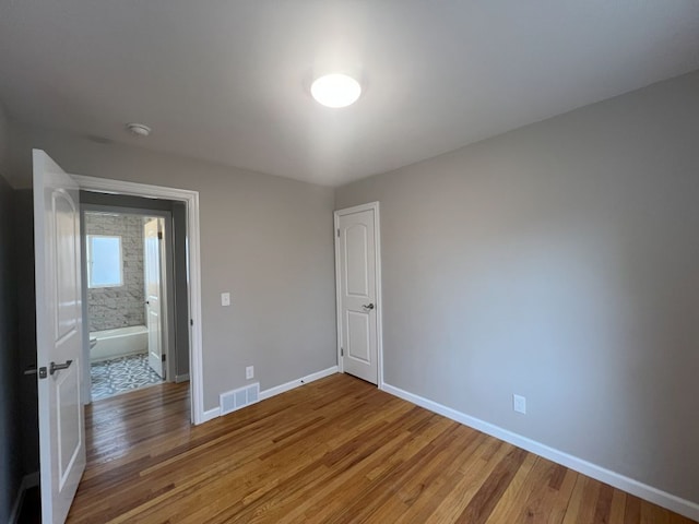 spare room with light wood-type flooring, baseboards, and visible vents