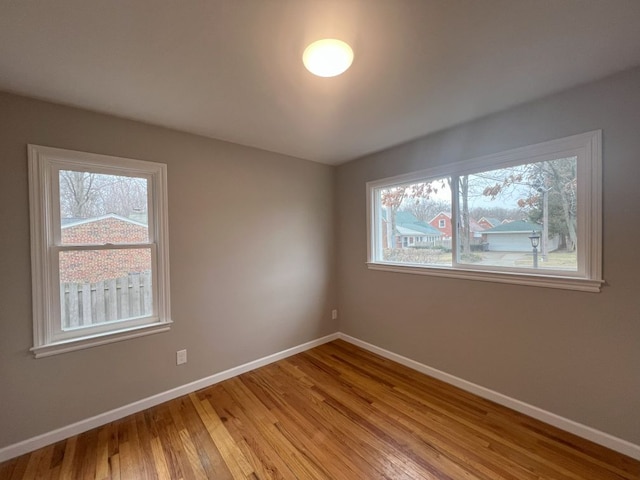 spare room featuring light wood-style flooring and baseboards