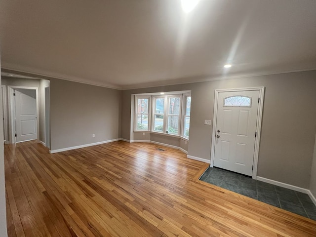 entryway with ornamental molding, baseboards, and wood finished floors