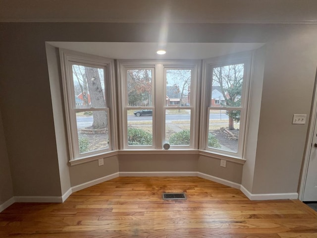 unfurnished dining area with light wood-type flooring, baseboards, and visible vents