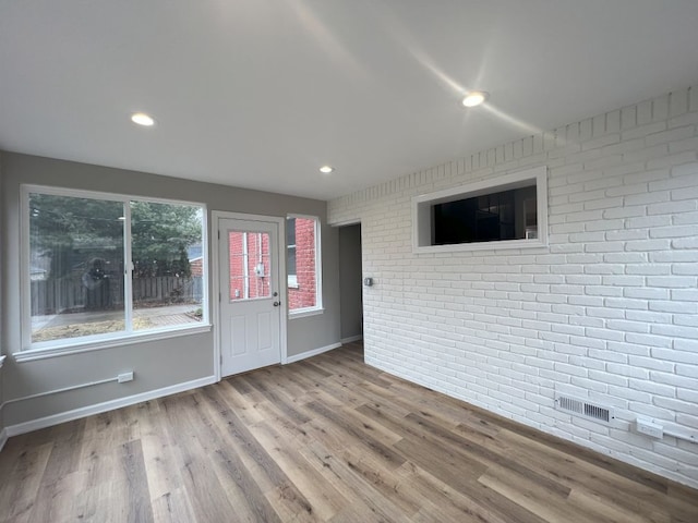 interior space featuring recessed lighting, visible vents, brick wall, wood finished floors, and baseboards