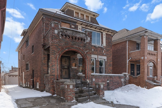 italianate house with a detached garage and brick siding