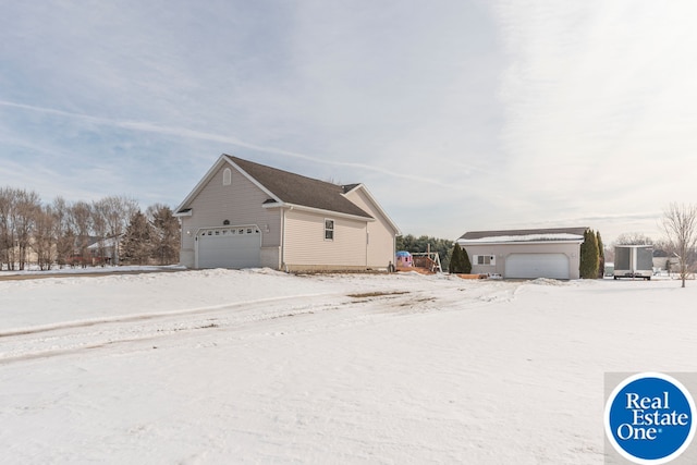 view of snow covered exterior with a detached garage